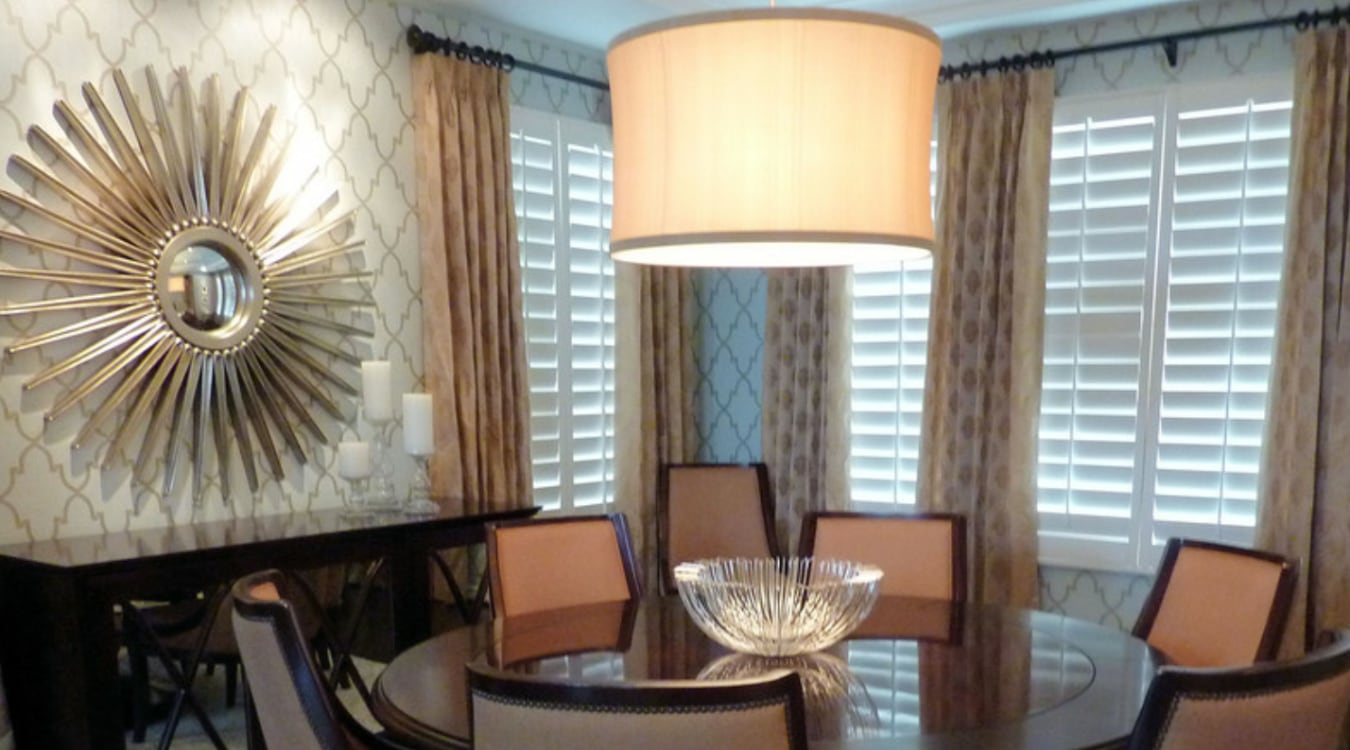 Plantation shutters with curtains in a dining room